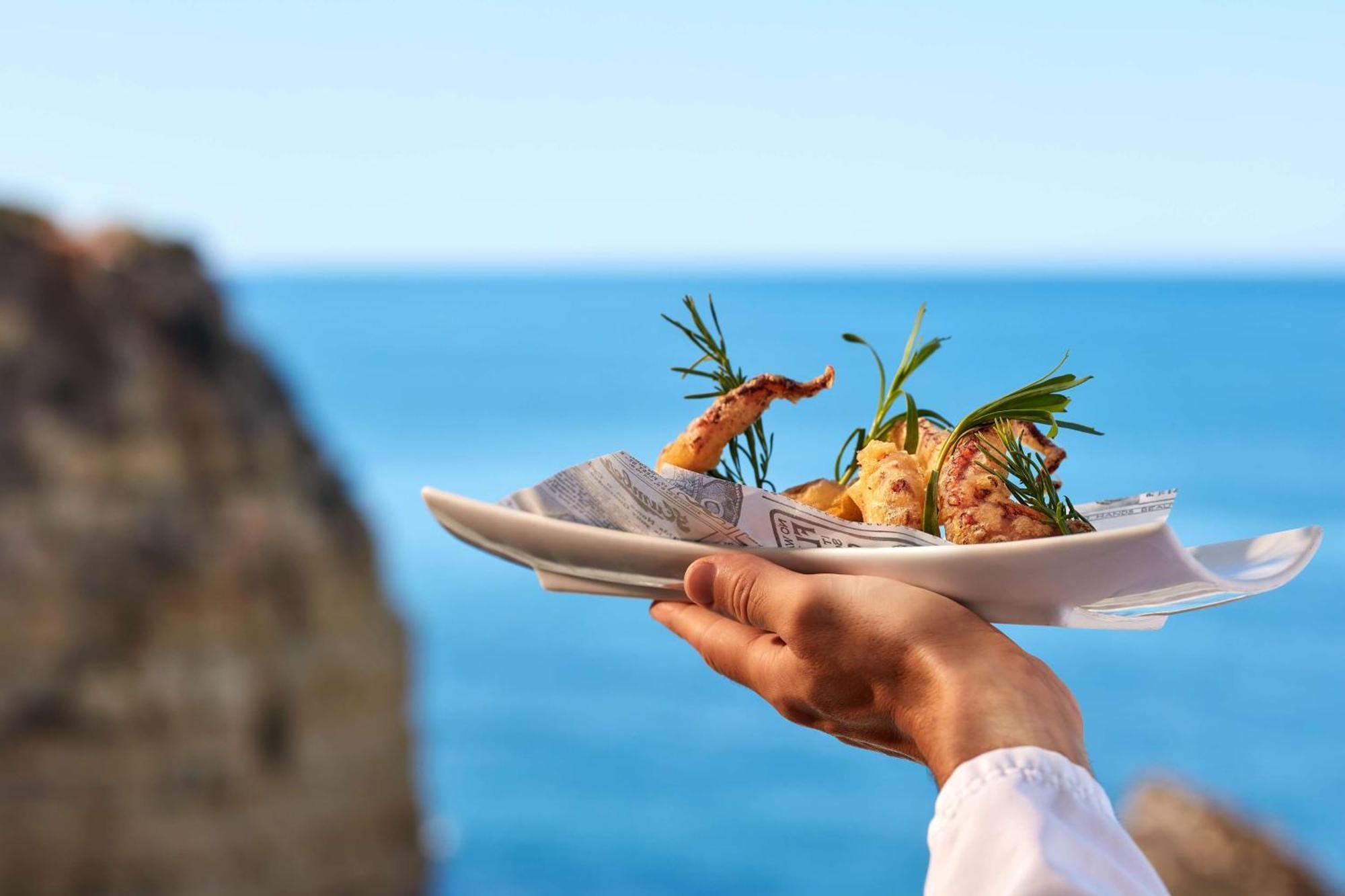 Готель Tivoli Carvoeiro Карвоейру Екстер'єр фото A waiter holding a plate of food
